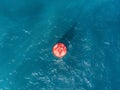 Floating red navigational buoy on blue sea, gulf. Drone Royalty Free Stock Photo