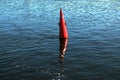 Floating red navigational buoy on blue water of Dnipro River. Royalty Free Stock Photo