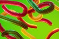 Floating sour gummy worms twisting on neon green Royalty Free Stock Photo
