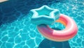 Floating star and ring pool toys in sunlit blue water Royalty Free Stock Photo