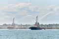 Tug boats spraying jets of water, demonstrating firefighting water cannons, fire boats spraying foam Royalty Free Stock Photo