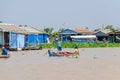 Floating village on the Tonle Sap Lake in Cambodia and kids row Royalty Free Stock Photo