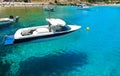 Floating in the water Boat on background beach and bathing people in Bay of Lindos, Rhodes Greece Royalty Free Stock Photo