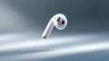 A floating white wireless earbud in a minimalistic style. This image captures modern technology in a sleek design. Perfect for Royalty Free Stock Photo