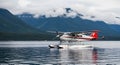 Floatplane aircraft rests on serene lake surface with misty mountains and lush forest backdrop Royalty Free Stock Photo