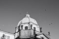 A flock of birds is flying over a dome of a baroque church Prague, Czech Republic Royalty Free Stock Photo