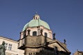 A flock of birds is flying over a dome of a baroque church Prague, Czech Republic