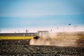 Flock Of Birds Of Seagull Flies Behind Tractor Plowing Field In