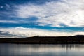 Flock of Geese flying over wintry frozen lake Royalty Free Stock Photo