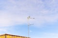 A flock of Laundress birds on a TV antenna against stunning blue sky with clouds