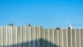 A flock of sparrows sitting on a metal fence at sunset against the blue sky