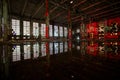 Flooded abandoned large industrial hall illuminated by red lights. Reflection in water. Abandoned Voronezh excavator plant Royalty Free Stock Photo