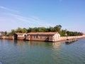 Flooded building and brick fence. Behind the fence is dense vegetation Royalty Free Stock Photo