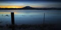 Flooded field at sunset with fence post and barbed wire. Royalty Free Stock Photo