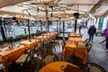 Flooded restaurant table and chairs on canal pathway on Grand Canal, Venice, Italy