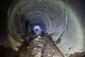 Flooded round sewer tunnel with dirty water and mud