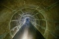 Flooded round sewer tunnel is reflecting in water