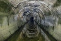 Flooded round underground drainage sewer tunnel reflecting in dirty sewage water Royalty Free Stock Photo