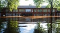 Flooded school building surrounded by trees, water reflecting the structure in sunlight. Royalty Free Stock Photo