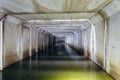 Flooded sewer tunnel is reflecting in water. Dirty urban sewage flowing throw rectangular sewer tunnel Royalty Free Stock Photo