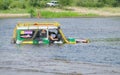 A flooded special car overcomes a deep ford in the river