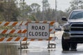 Flooded street in Florida after hurricane rainfall with road closed signs blocking driving of cars. Safety of Royalty Free Stock Photo