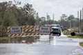 Flooded street in Florida after hurricane rainfall with road closed signs blocking driving of cars. Safety of Royalty Free Stock Photo