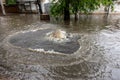 Flooding after heavy rains in city. Sewage broke open asphalt and blew up fountain. Dirty sewage broke through storm sewer and Royalty Free Stock Photo