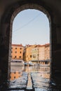 Flooding sea water in the port of Cres city, looking through a stone arch of a house. Nice view through the gate, sea flooding a