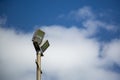 Floodlights above a football pitch with blue sky and clouds in the background