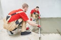 Floor cement work. Plasterer smoothing floor surface with screeder