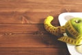 Floor scales, tape measure and green apple on a wood background top view. The concept of a healthy diet, body weight Royalty Free Stock Photo