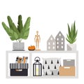 Floor table with interior items. A plant, pillows, boxes, a wooden figurine, a pumpkin, small houses and a flashlight.