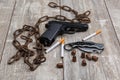 On the floor is an rusty chain, a pistol, a few ammunition and several cigarettes with a filter. Royalty Free Stock Photo