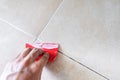 Floor tile fixing and renovation, Hand using trowel repairing old tile grout in bathroom Royalty Free Stock Photo