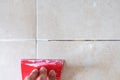 Floor tile fixing and renovation, Hand using trowel repairing old tile grout in bathroom Royalty Free Stock Photo