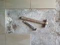 Floor tile removal. Old tools on floor. Dismantling old floor tiles. Renovations.Chisel and hammer on concrete slab