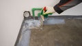 Floor waterproofing membrane on concrete floor. On the floor, the master applies white waterproofing. Floor