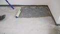 Floor waterproofing membrane on concrete floor. On the floor, the master applies white waterproofing. Floor