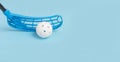 Floorball stick and white ball isolated on blue background Royalty Free Stock Photo