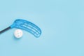 Floorball stick and white ball isolated on blue background Royalty Free Stock Photo
