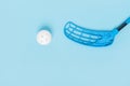 Floorball stick and white ball isolated on blue background Royalty Free Stock Photo