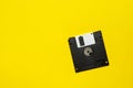 Floppy data storage diskette on yellow background with copy space