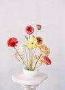 A floral arrangement of ranuncules, roses, sweet peas and citrus fruit