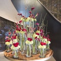 Floral arrangement with red roses, twigs of flowering quince, callas in different glass vases