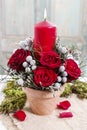 Floral arrangement with red roses, brunia and candle in ceramic pot Royalty Free Stock Photo