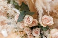 Floristic composition of cream roses, eucalyptus twigs and pampas grass.