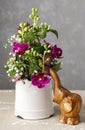 Floral arrangement with violet orchids and wooden figure of baby Royalty Free Stock Photo