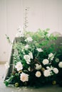 Floral arrangement of white delicate flowers and fresh greenery in the design of the wedding table of the bride and groom in white