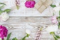 Floral background with peonies and handmade gift box. White paint wooden background.